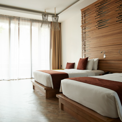 Luxury hotel-style bedroom with a plush king headboard, blackout drapery, and a dedicated seating area with elegant armchairs.